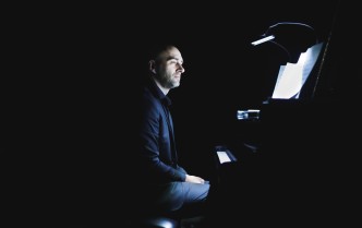 mężczyzna siedzący przy fortepianie