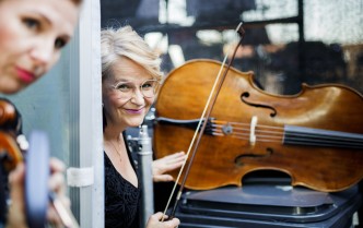 Two women smiling at a cello