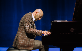 Man slightly hunched over at the piano 