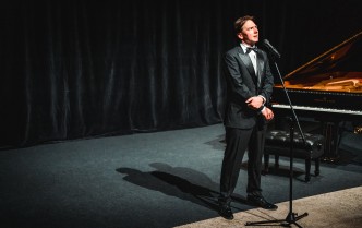 mężczyzna stojący obok fortepianu