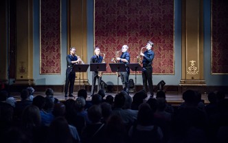 czterech mężczyzn grających na saksofonach