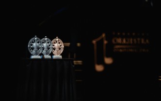 trzy statuetki o owalnym kształcie w środku ze skrzypcami, z lewej strony dwie w kolorze srebrnym, od prawej jedna w kolorze złotym