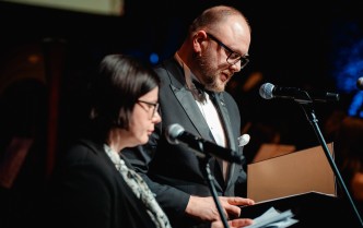 kobieta i mężczyzna mówiący do mikrofonu