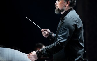 mężczyzna trzymający batutę w podniesioniej ręce