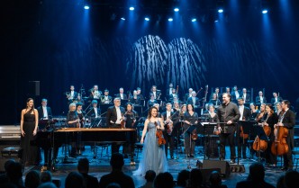 solistki, dyrygent i orkiestra stoją na scenie