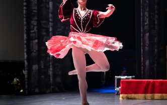 baletnica w różowej sukience, z uniesionymi rękoma