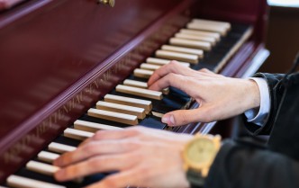 dłonie ułożolne na krawiaturze klawesynu