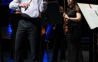 mężczyzna w białej koszuli gra na skrzypcach