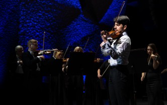 mężczyzna w białej koszuli gra na skrzypcach