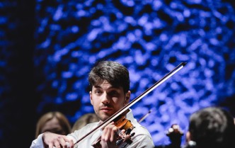 mężczyzna w białej koszuli gra na skrzypcach