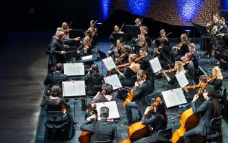 orkiestra siedzi na scenie, widok z góry