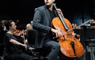 mężczyzna w czarnym garniturze gra na wiolonczeli