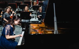 kobieta w koronkowej sukni gra na fortepianie