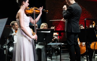 kobeta w jasnej sukni gra na skrzypcach