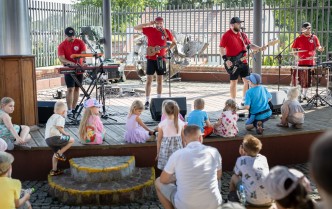 czterech meżczyzn w czerwonych koszulkach grających na instrumentach