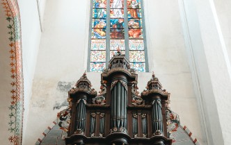 zdjęcie w pionie, zrobione z dolnej perspektywy, organy barokowe oraz witraż nad nim
