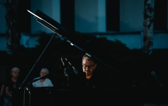 zbliżenie na pianistę, widzimy jego głowę między fortepianem