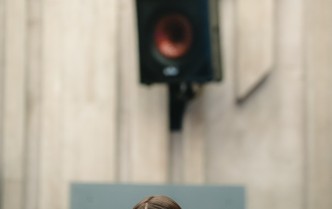 kobieta - prowadząca warsztaty ukazana od klatki piersiowej w górę, z uniesionymi dłońmi na wysokości żuchwy