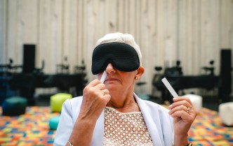 zbliżenie na kobietę z zasłoniętymi oczami, wąchająca próbki zapachów