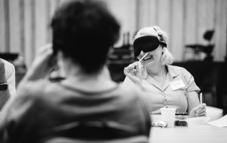 czarno-białe zdjęcie, roześmiana kobieta w opasce przykłada zapach do nosa