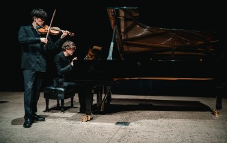 mężczyzna grający na skrzypcach i mężczyzna grający na fortepianie