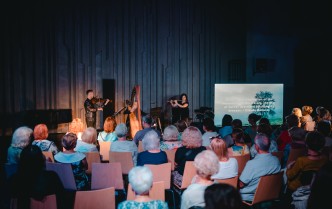 muzycy grający na scenie i publiczność na widowni