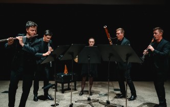 czworo mężczyzn i kobieta grających na instrumentach dętych
