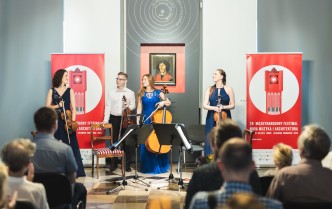 mężczyzna i trzy kobiety trzymają instrumenty smyczkowe