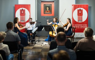 mężczyzna i trzy kobiety trzymają instrumenty smyczkowe