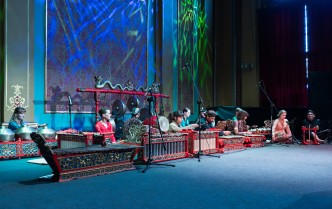 osobysiedzące na podłodze i grające na instrumntach muzycznych