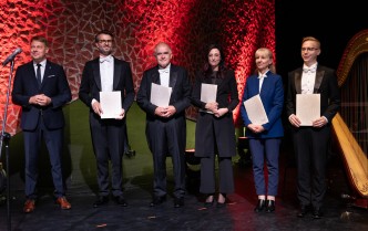 sześć osób trzymających teczki pozuje do zdjęcia