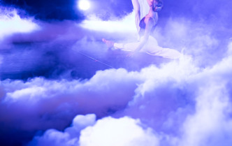 kobieta robiąca szpagat, obok niej stoi mężczyzna