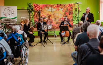 kobieta i trzech mężczyzna trzymających instrumenty smyczkowe