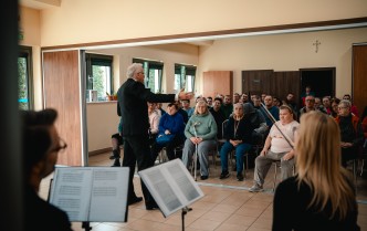 mężczyzna stojący przed siedzącą grupą ludzi