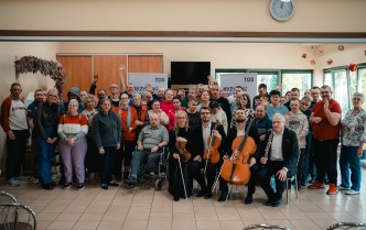 zdjęcie grupy stojących i siedzących osób
