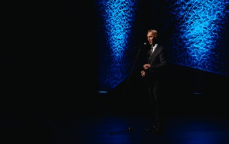 stojący mężczyzna mówi do mikrofonu