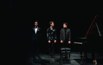 trzech mężczyzn stoi obok fortepianu