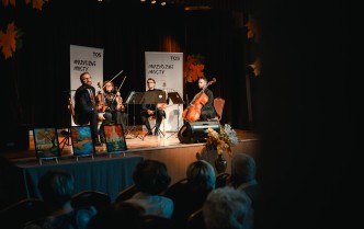 czworo muzyków trzymających instrumenty smyczkowe