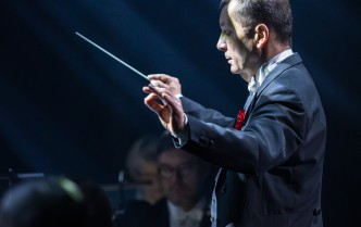 mężczyzna trzymający w dłoni batutę