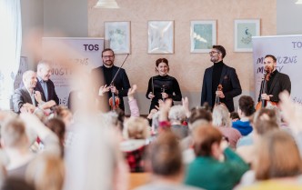 cztery stojące osoby w czarnych ubraniach