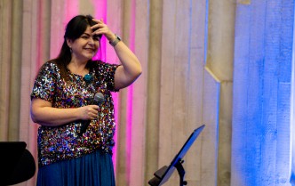 uśmiechnięta kobiera w kolorowej bluzce i niebieskiej spódnicy