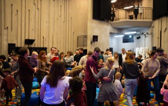 dzieci i dorośli stoją na dywanie