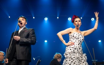 kobieta i mężczyzna śpiewający do mikrofonów