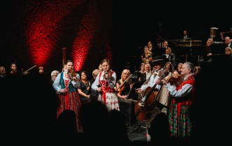 kobiety i mężczyzna w strojach góralskich grają na instrumentach muzycznych