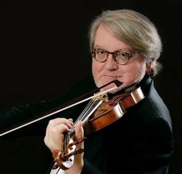 mężczyzna gra na skrzypcach na ciemnym tle