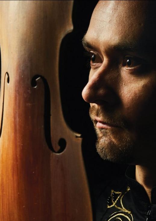 The man's face next to the soundboard of violins