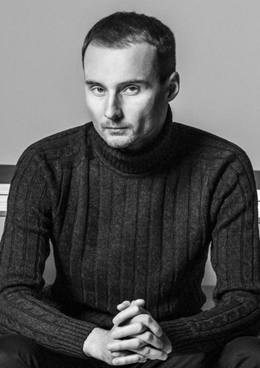 young man seated with his hands on his lap