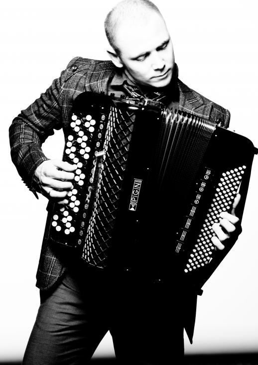 black and white photo of a man playing the accordion