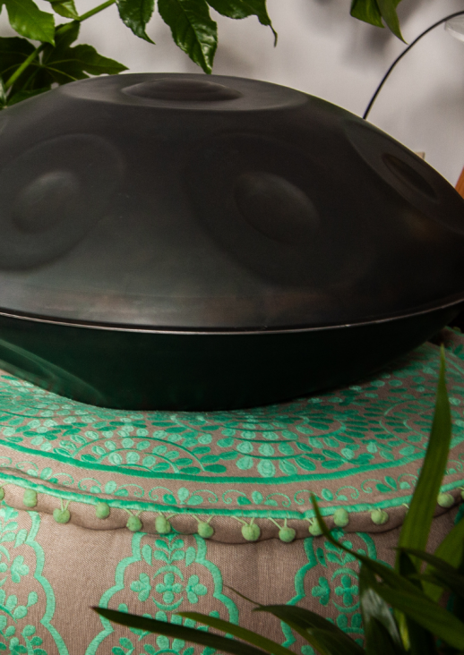 a handpan musical instrument lying on a pillow