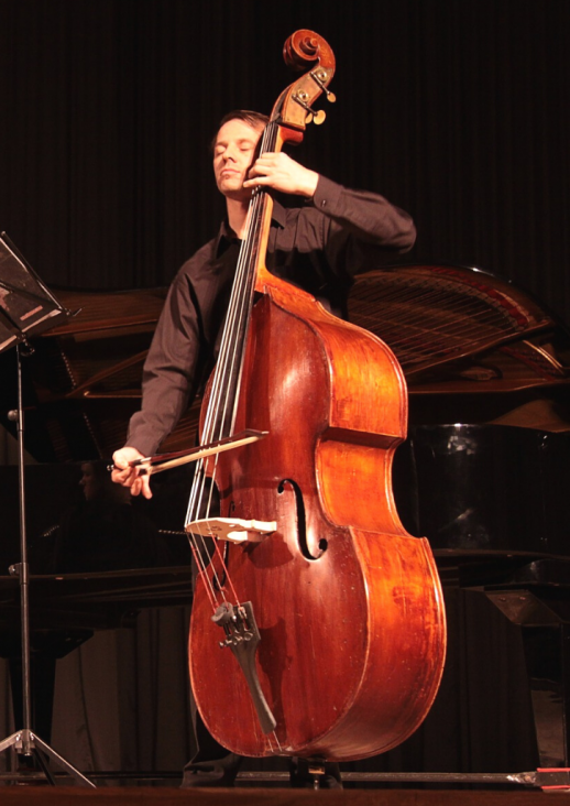 The man playing the double bass and the title of the concert